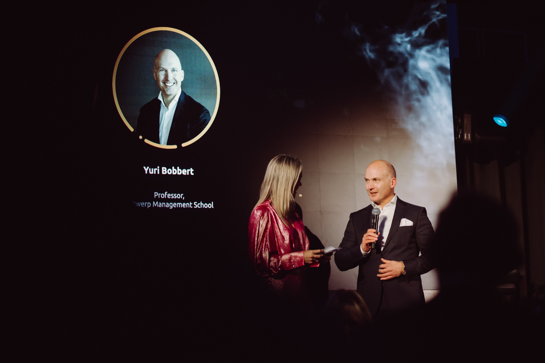 Yuri Bobbert moderating an industry awards stage, microphone in hand